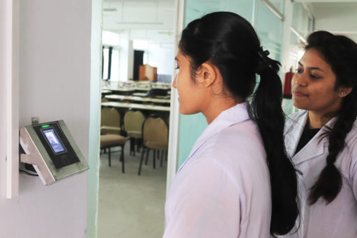 Student stands before the face regonition device for identity verification at class door
